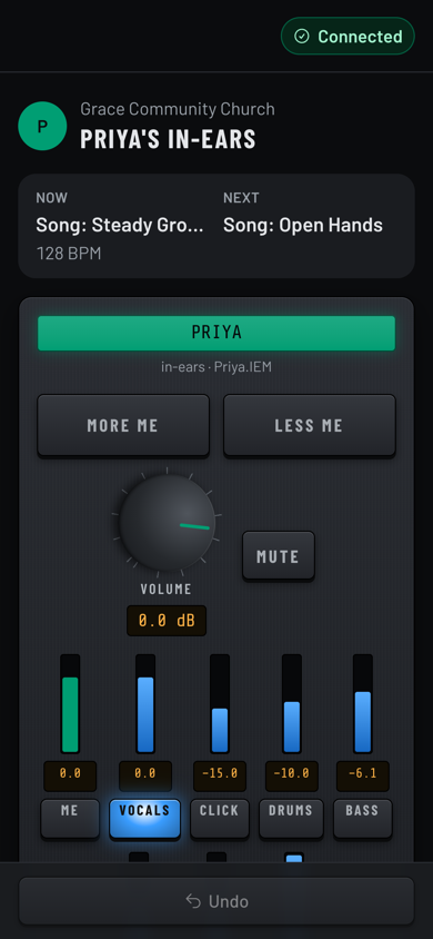 A phone showing Priya's in-ears: the current and next song, More me and Less me buttons, a volume knob, and sliders for me, vocals, click, drums and bass. (Dark room version)